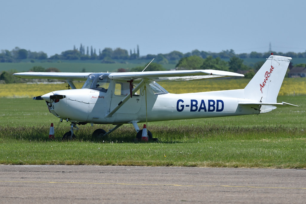 A light general aviation aircraft parked on a grass airfield