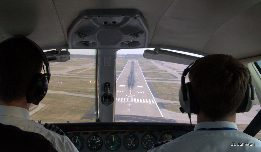 Two pilots in the cockpit of a light aircraft on final approach